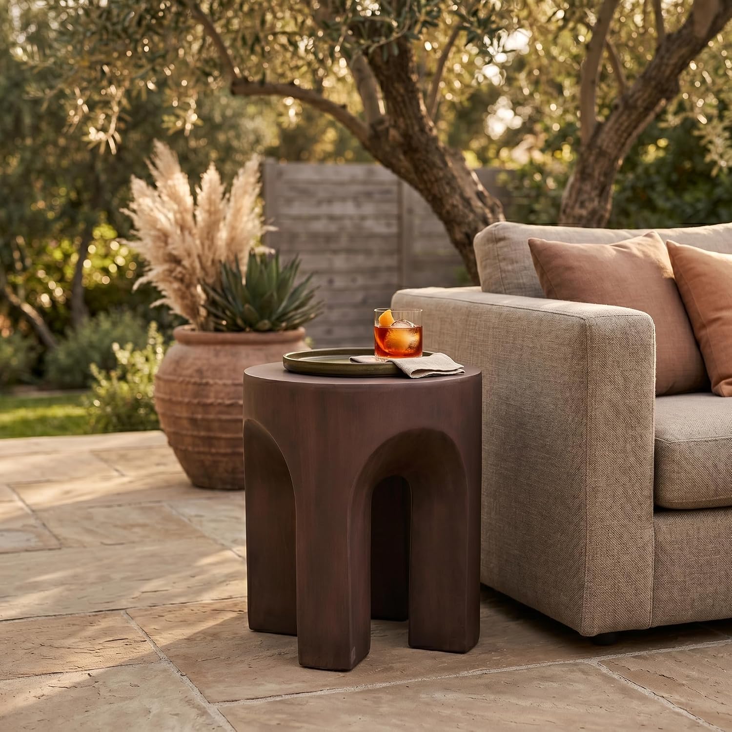 LeisureMod Round Side Table in Fiberstone with Arched Base Design Compact Weather-Resistant for Modern Home, Living Room, Bedroom, Patio Crus Collection (Wood Brown)